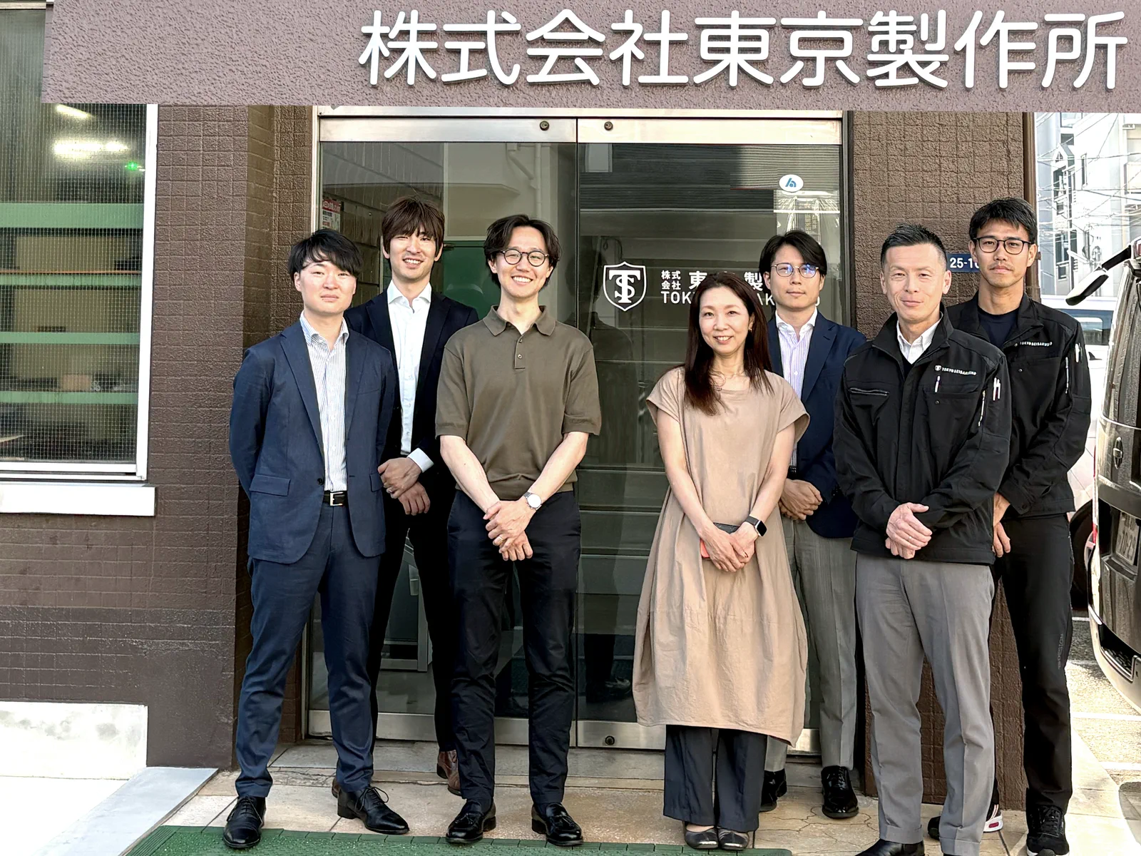 株式会社東京製作所の入口前で並ぶ東京製作所とTOMOSEの関係者